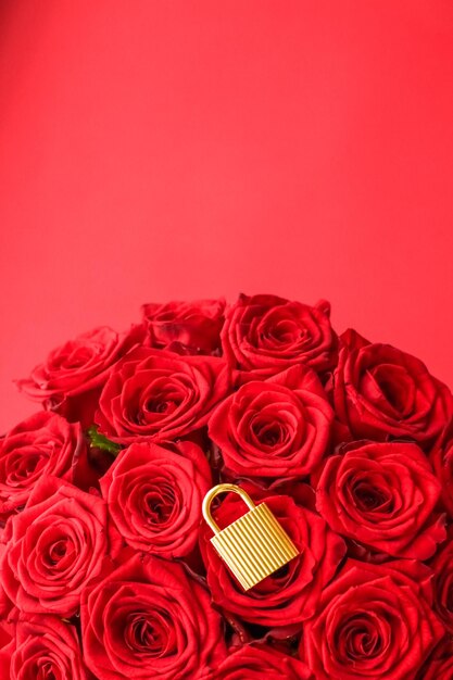 Love lock for Valentines Day card golden padlock and luxury bouquet of roses on red background