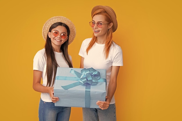 Love mom Smiling mother and daughter with gift box Cheerful mom and her cute daughter girl with