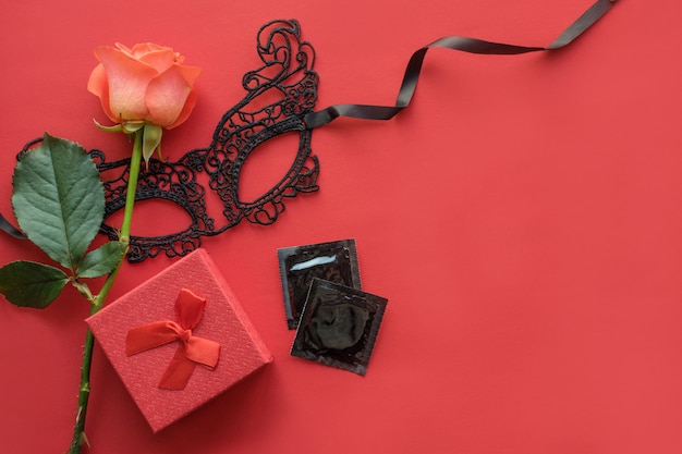 Love, passion, sex romance flat lay, mock up with red rose, lace mask, gift box 