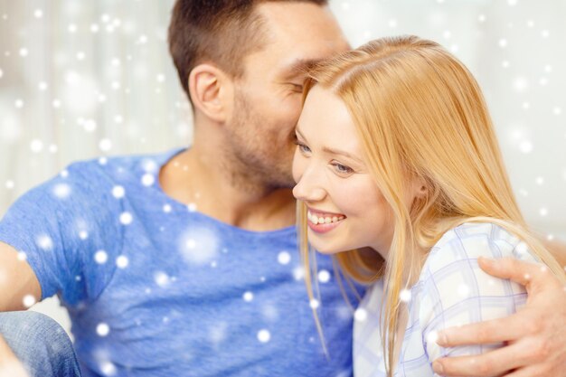 Love, people and family concept - smiling couple hugging at\
home