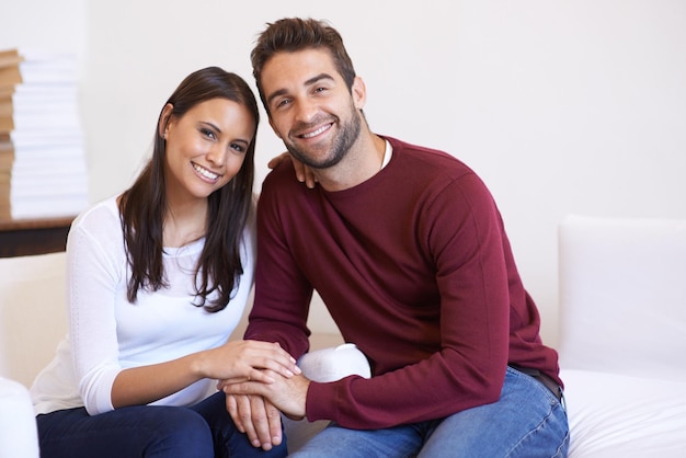 Love portrait and happy couple on a sofa with care trust and security support or bonding at home Marriage commitment and face of people in a living room with romance care or peace in a house