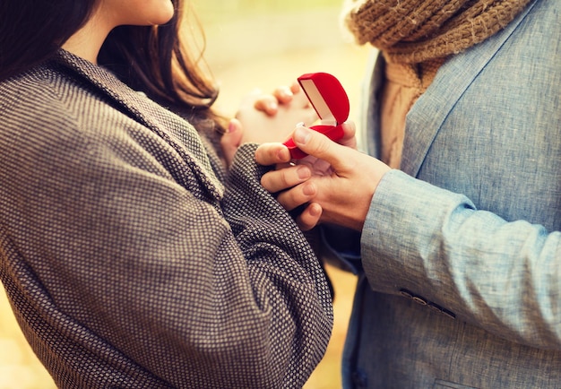Фото Концепция любви, отношений, семьи и людей - крупный план пары с красной подарочной коробкой в осеннем парке