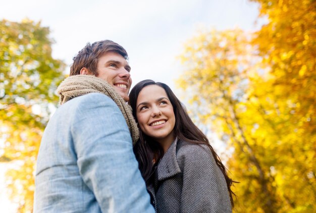 love, relationship, family and people concept - smiling couple hugging in autumn park