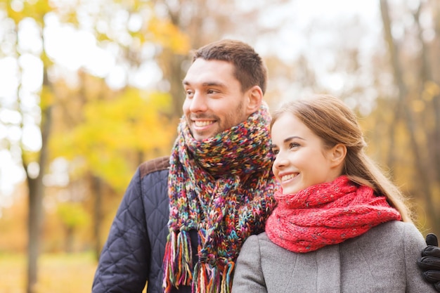 愛、関係、家族、季節、人々の概念-秋の公園の橋に抱き締める笑顔のカップル