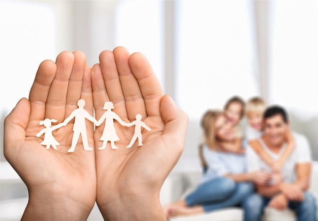 Love and relationships concept - closeup of man's cupped hands showing paper  family