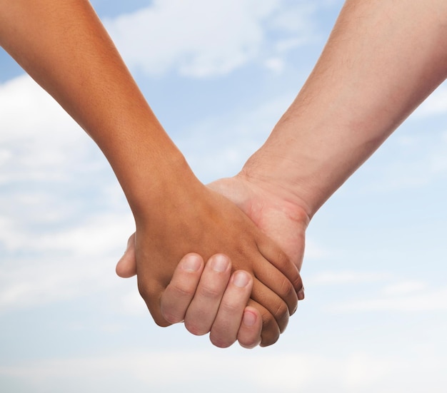 love and relationships concept - closeup of woman and man holding hands