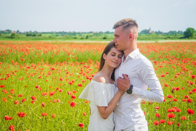 Love and romance romantic relationship beautiful couple in love man and woman in poppy flower field summer vacation happy family among red flowers spring nature beauty copy space