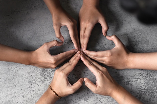 Love shaped by people hands in a group of diverse people connected together as a support symbol