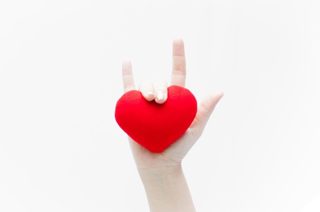 Love sign by woman hand and red heart shape on white background close-up,Symbol of love or dating