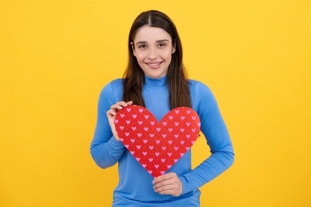 幸せな女性のバレンタインデーや誕生日の愛のサイン 幸せな女性は美しい赤いハートを保持します