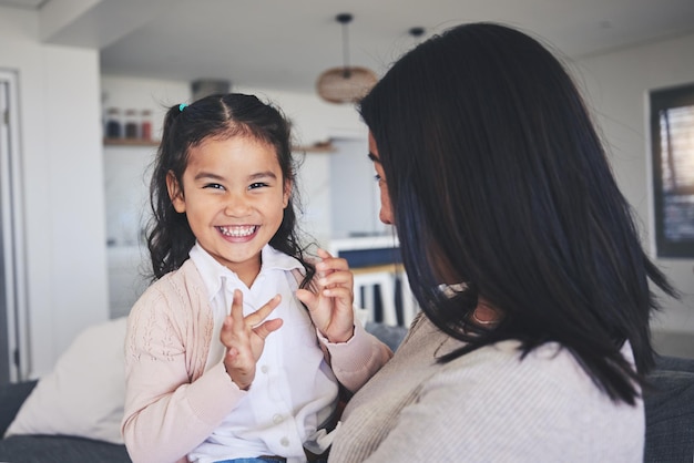 Love smile and portrait of mother and daughter on sofa for playful care or support Happy calm and relax with woman and young girl embrace in living room of family home for peace cute and bonding