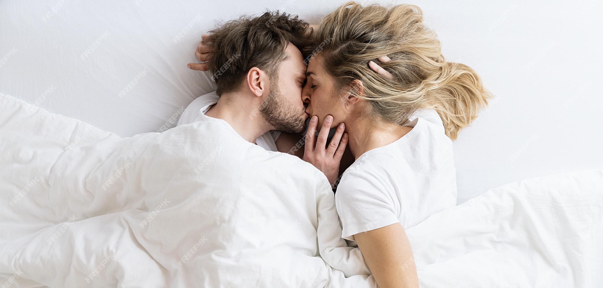 Premium Photo | Love story. couple kissing lying on the bed in a ...