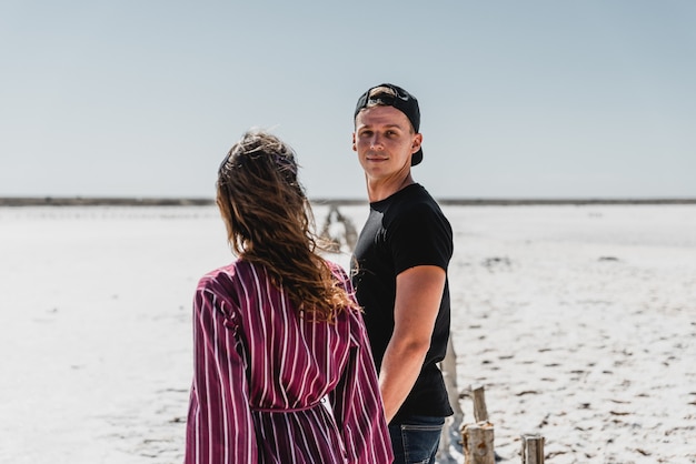 Love story in the desert,  happy young couple, young people are walking and holding hands, summer vacation for a young couple