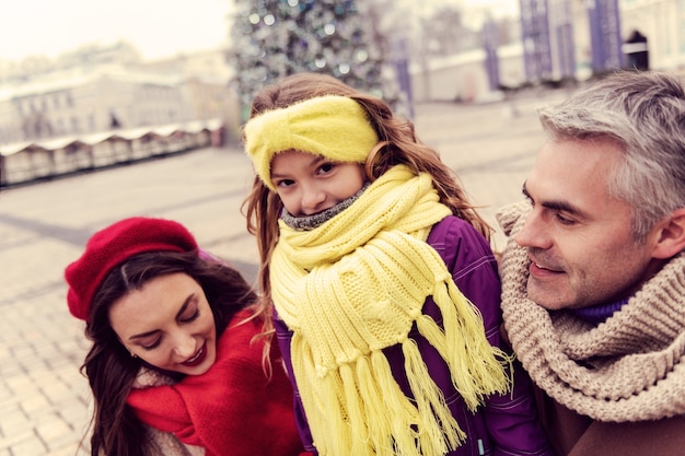 Love them. Handsome man expressing positivity while walking with his family