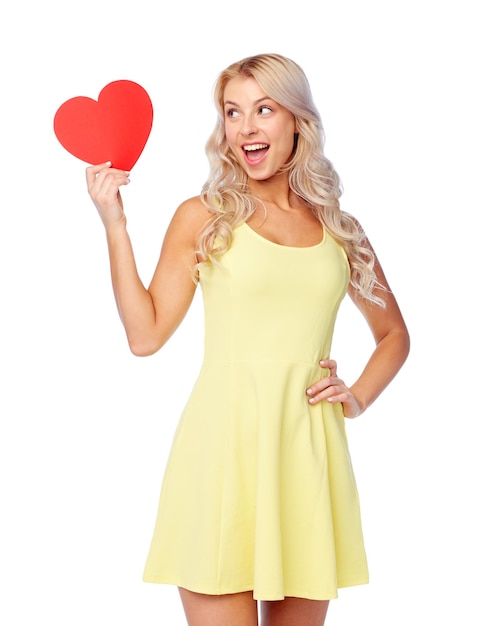 Photo love, valentines day and people concept - smiling young woman in dress with red paper heart