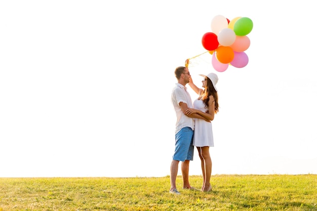 love, wedding, summer, dating and people concept - smiling couple wearing sunglasses with balloons hugging outdoors