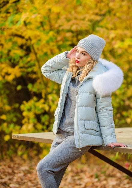 Foto innamorato della natura. ragazza sportiva con piumino. indossare abiti comodi. vestiti caldi per la stagione autunnale. la donna con il cappello si gode l'autunno. camminare nel parco. la ragazza si rilassa tra le foglie cadute. tuta sportiva accogliente.