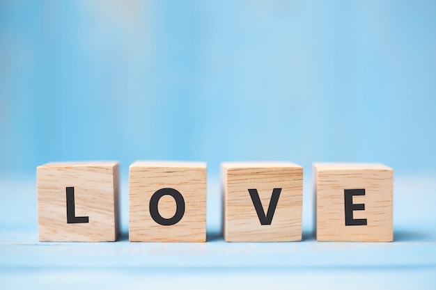 LOVE wooden cubes on blue table background 