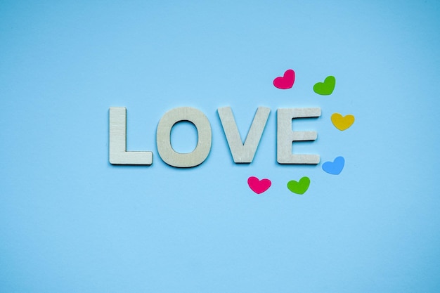 love wooden letters and heart shapes on the blue background for valentine's day