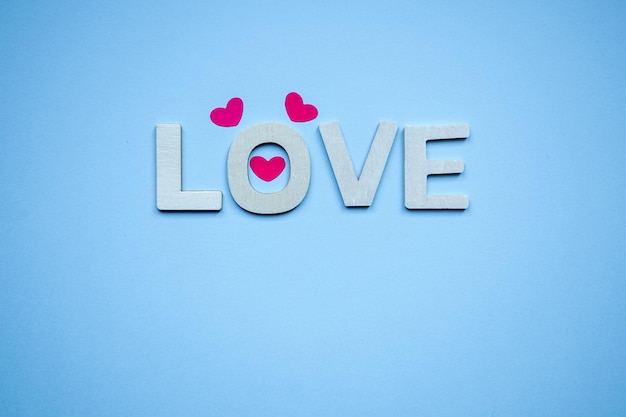 love wooden letters and heart shapes on the blue background for valentine's day