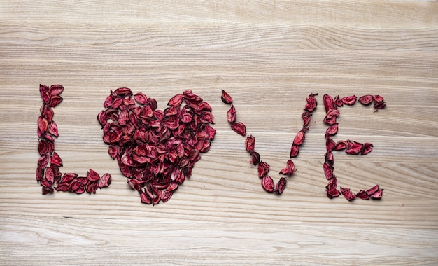 Love word and heart made of rose petal.