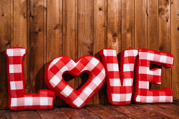 Love word of plush red letters on wood background