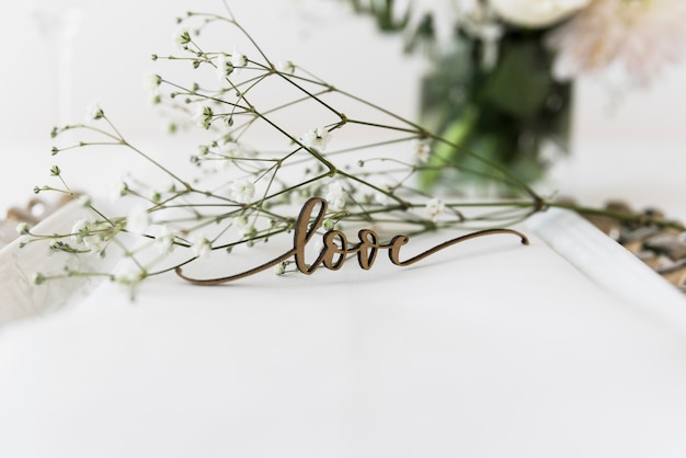 Love word and white flowers on plate