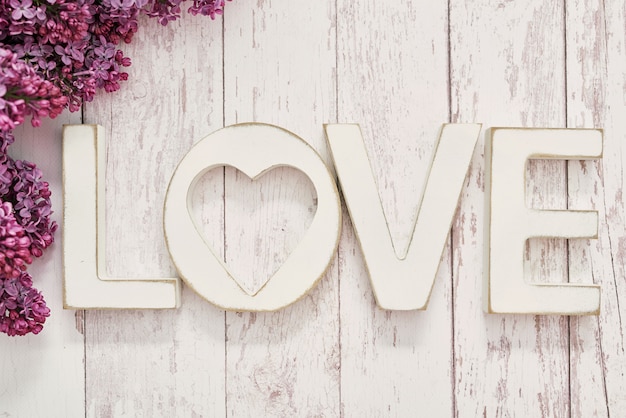 Love word with purple lilac flowers