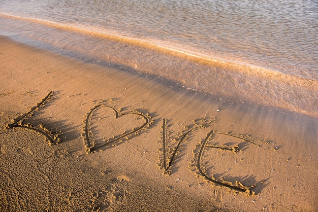 Love word written in sand