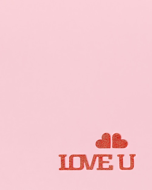 Love you in red and bright letters with hearts on pink background with copy space