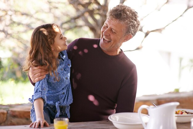 Love you so much my darling Shot of a little girl and her grandfather having breakfast together outside