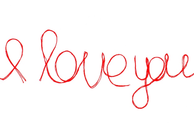 あなたのバレンタインデーのために分離された赤い糸で作られた言葉とハートのシンボルを愛してください