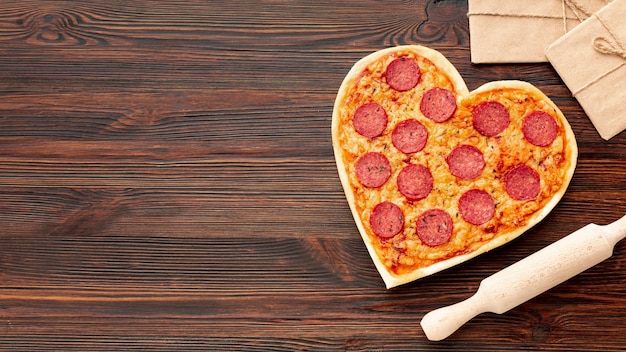 ハート型のピザとコピースペースとのバレンタインデーディナーの素敵なアレンジメント