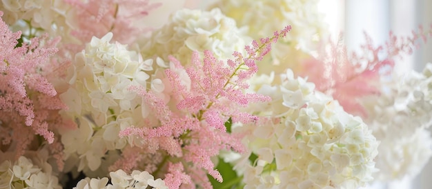 A lovely arrangement of white hydrangeas and pink astilbe showcased indoors seen up close