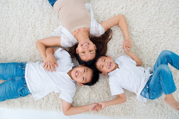 Lovely asian family lying on the floor