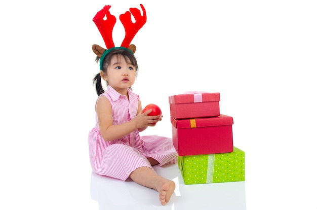 사랑스러운 아시아 여자 아이 사과 들고 및 크리스마스 선물 상자