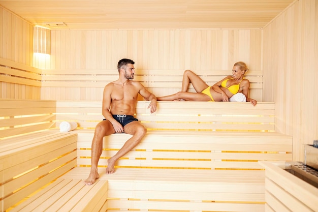 A lovely attractive couple in bathing suit enjoying the moments together and relaxing in a sauna