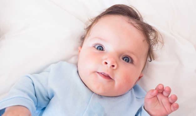 Lovely baby boy lying in bed