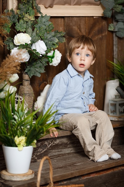 Lovely baby boy playing with easter bunny in a green grass