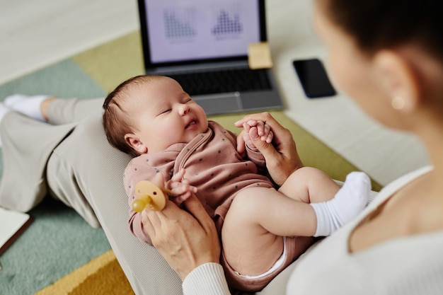 Photo lovely baby lying on mothers lap