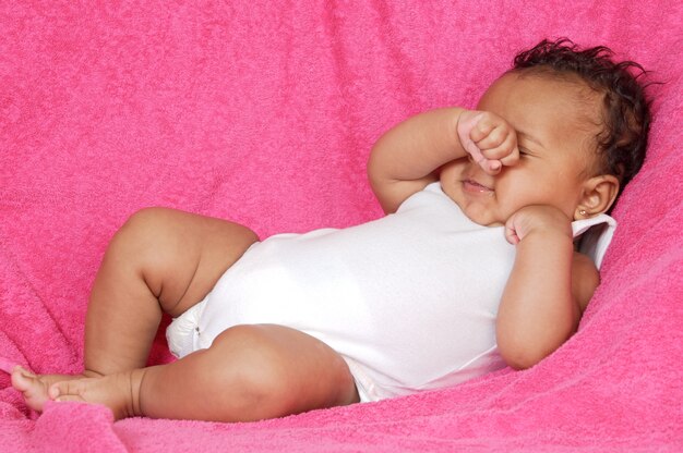 Lovely and beautiful baby on a pink towel