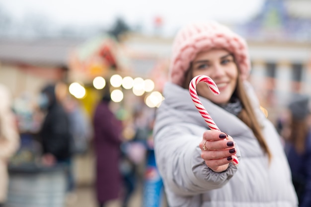 クリスマスフェアでキャンディーと素敵な金髪の女性。テキスト用のスペース