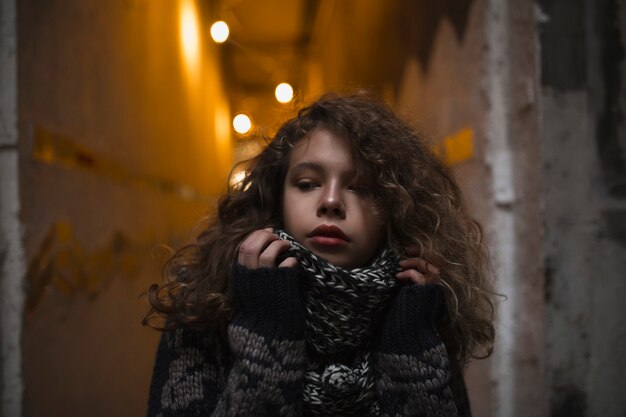 Photo lovely blonde model posing in the dark corridor with lights