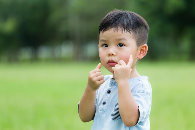 Lovely boy with finger on his face