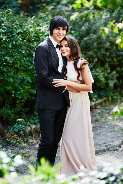 Lovely bride and bridegroom standing close to each other at park, wedding photo, beautiful couple, portrait.