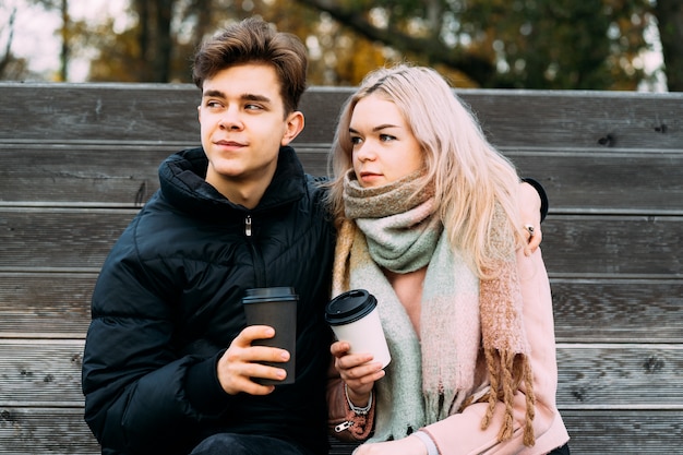 Lovely brunette guy and pretty girl blonde drink coffee and chat on date, dreaming. 