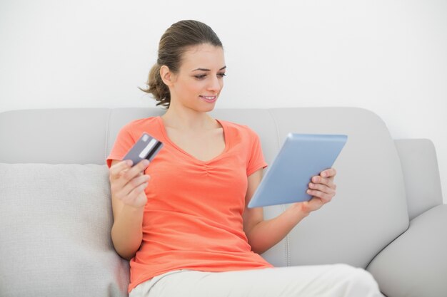 Lovely brunette woman home shopping with her tablet 