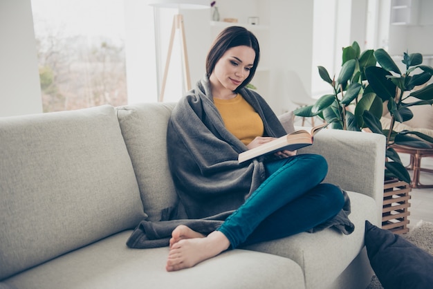 Lovely brunette woman posing indoors with a book