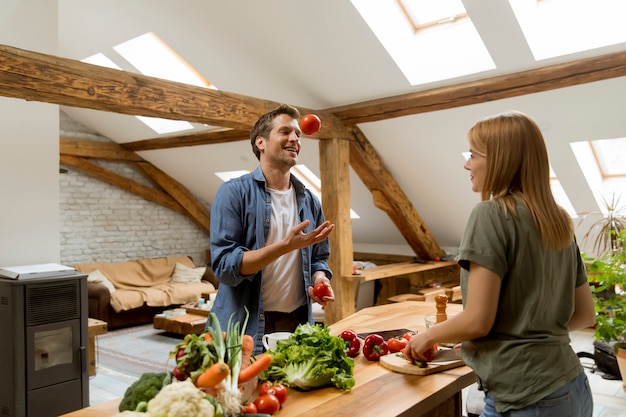 Lovely cheerful young couple cooking dinner together