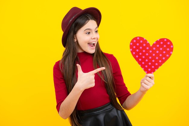 Lovely child girl 12 13 14 years old with shape heart love holiday and valentine symbol valentine or birthday day excited teenager glad amazed and overjoyed emotions